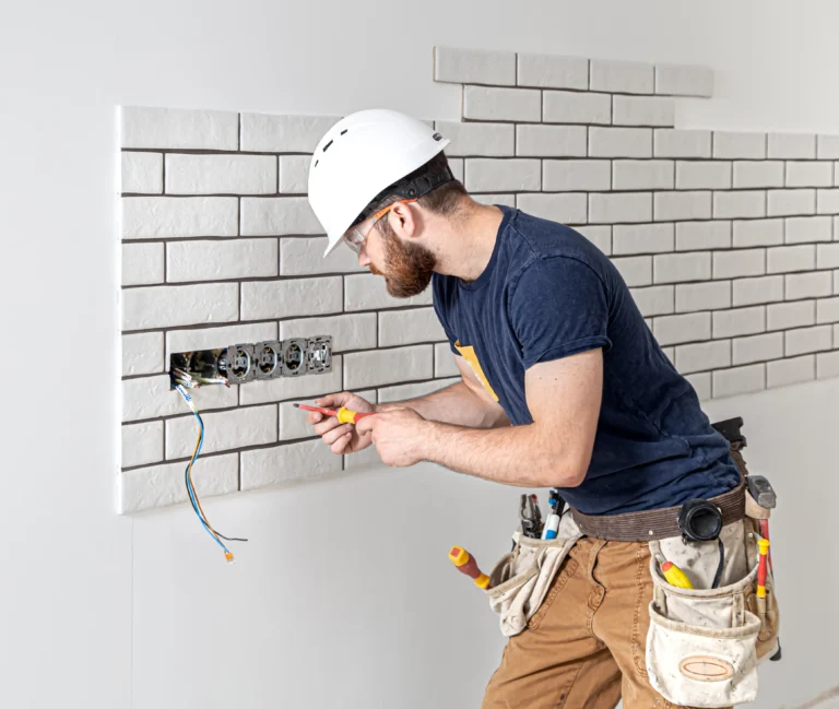 trabajador-de-la-construccion-electricista-con-barba-en-monos-durante-la-instalacion-de-enchufes-concepto-de-renovacion-del-hogar